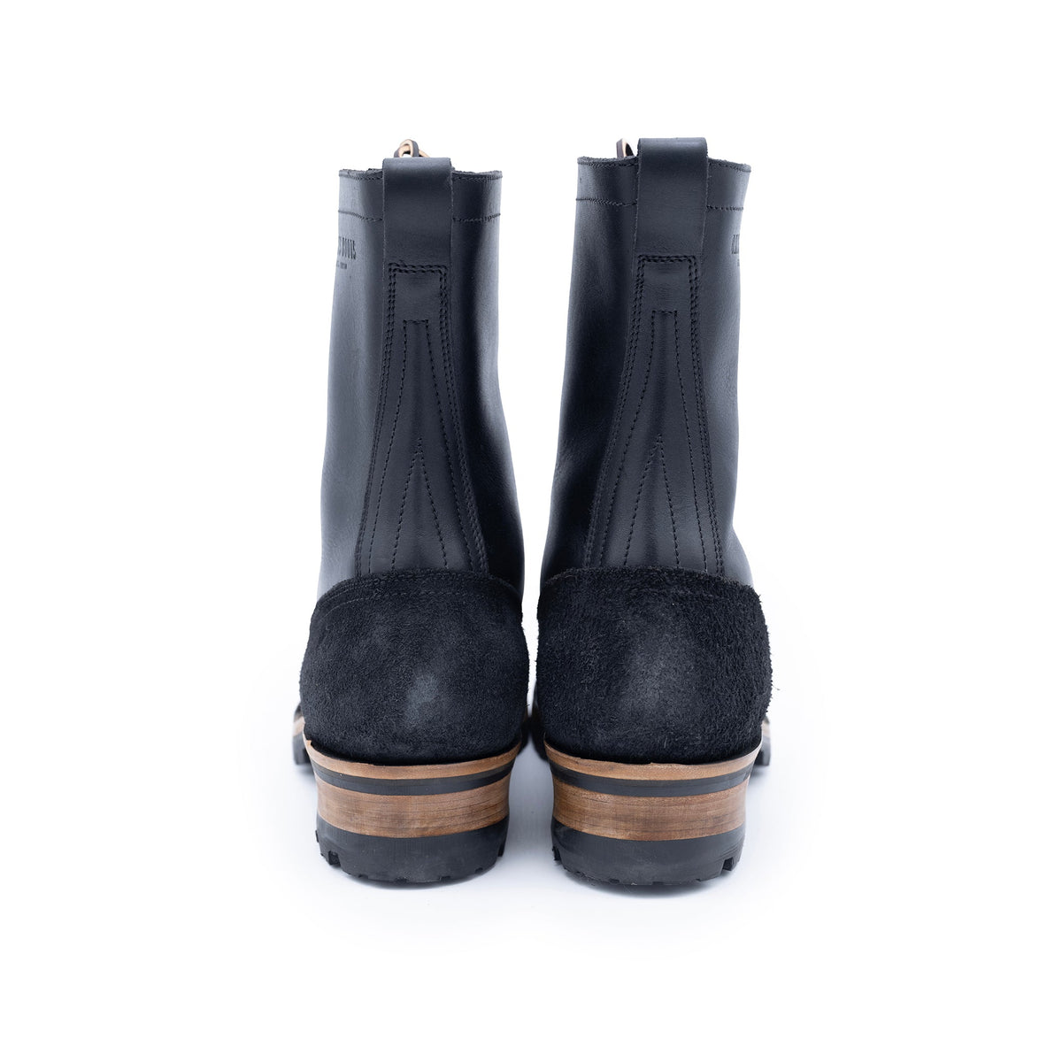 Pair of black rubber rain boots with suede soles on a white background