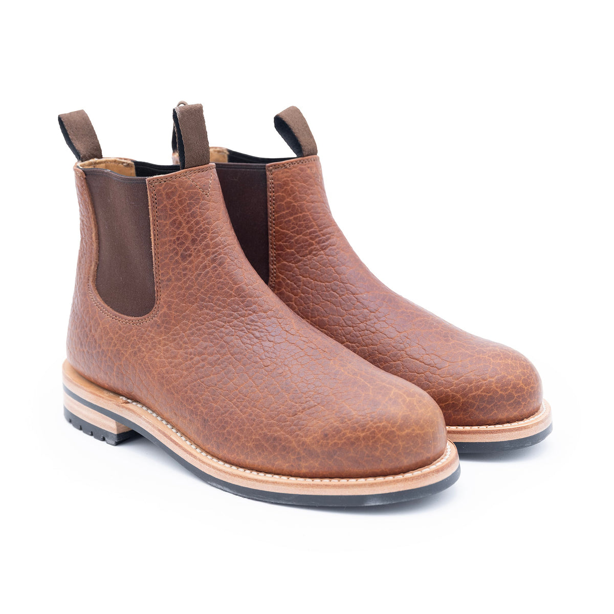 Pair of brown leather Chelsea boots on a white background